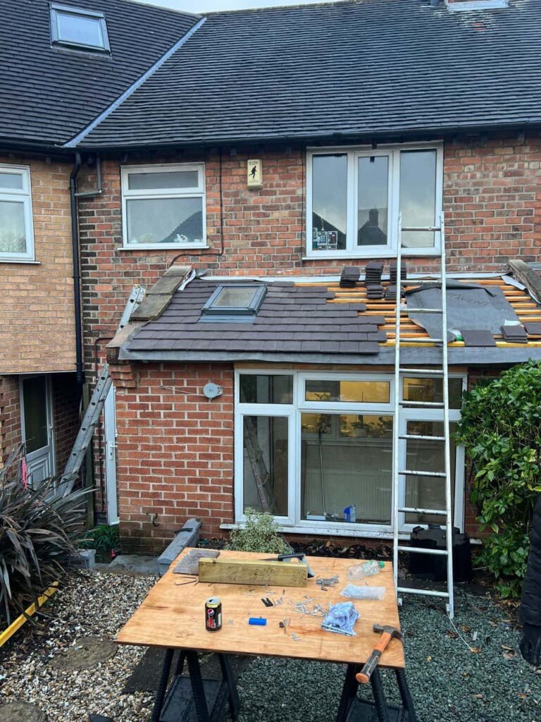 This is a photo of a roof extension that is having new roof tiles installed. This is a photo taken from the roof ridge looking down a tiled pitched roof on to a flat roof. Works carried out by Greenhithe Roofing Repairs