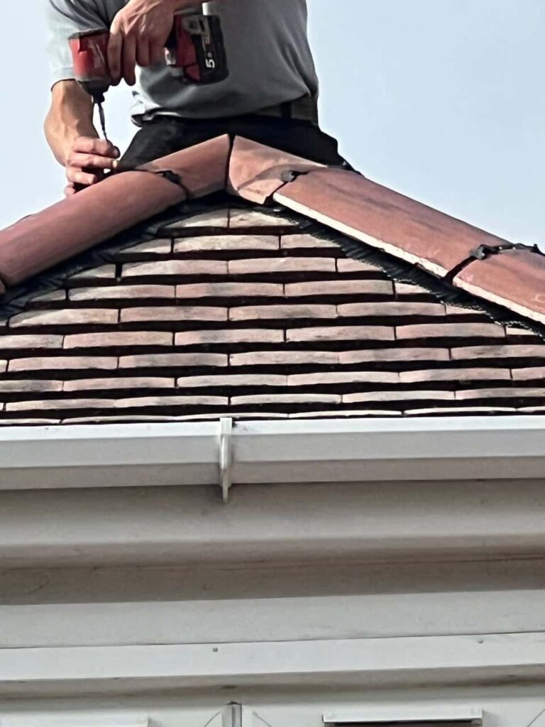 This is a photo of one of the operatives of Greenhithe Roofing Repairs installing new ridge tiles